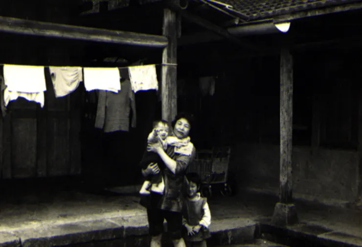 攝於民國63年，筆者母親陳勤抱著我的長子，與長女在三合院庭前 