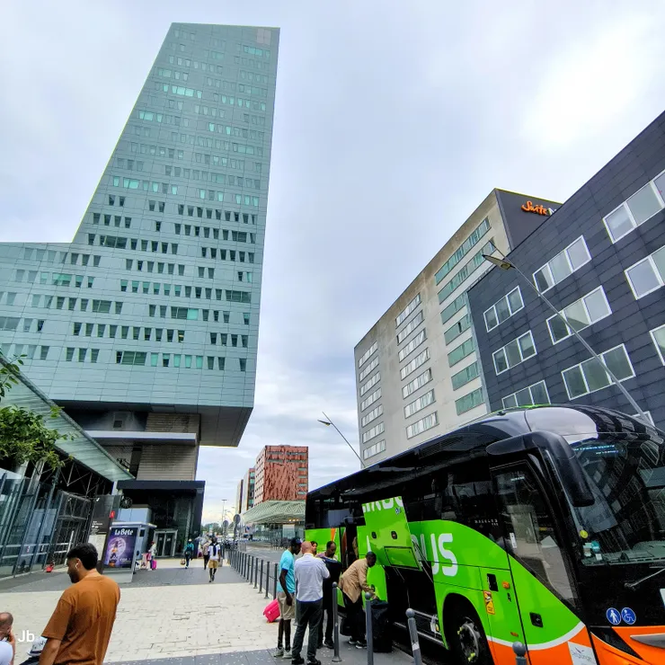 【搭飛力巴士也須謹記防搶要訣，李儘量往裡放下車保持警覺。終點望見里爾塔！Bus終點站在里爾歐洲車站東側，下車即望見新地標L形的摩天辦公大樓里爾塔，怡青要我們待在這裡，她走過來。】