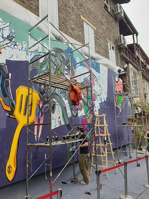街頭塗鴉藝術家在彩繪牆壁，讓此處有流行時尚之感