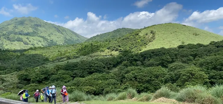 層層山巒環抱的擎天崗上朝聖的山友們