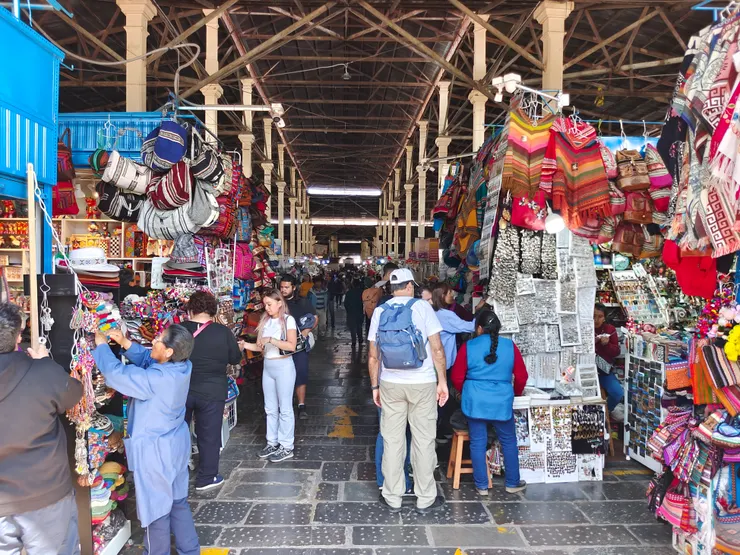 市場為挑高鋼構建築，入口處是琳瑯滿目的傳統織品攤位。