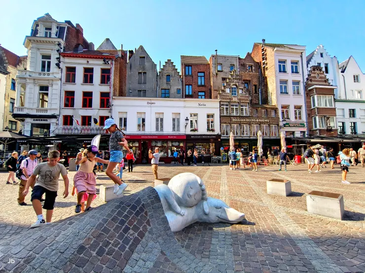 【聖母大教堂前龍龍與狗睡得正甜 藝術昇華悲傷招徠兒童無憂笑顏！現場好些小朋友在龍龍與忠狗的蓋被上跳躍嬉戲，十分歡樂。】