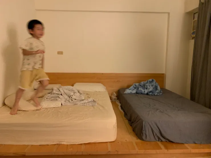 木質大床架讓人有放鬆感，同時能有效隔絕濕氣。簡單放一張雙人床和一張單人床，十分適合有幼兒的家庭。