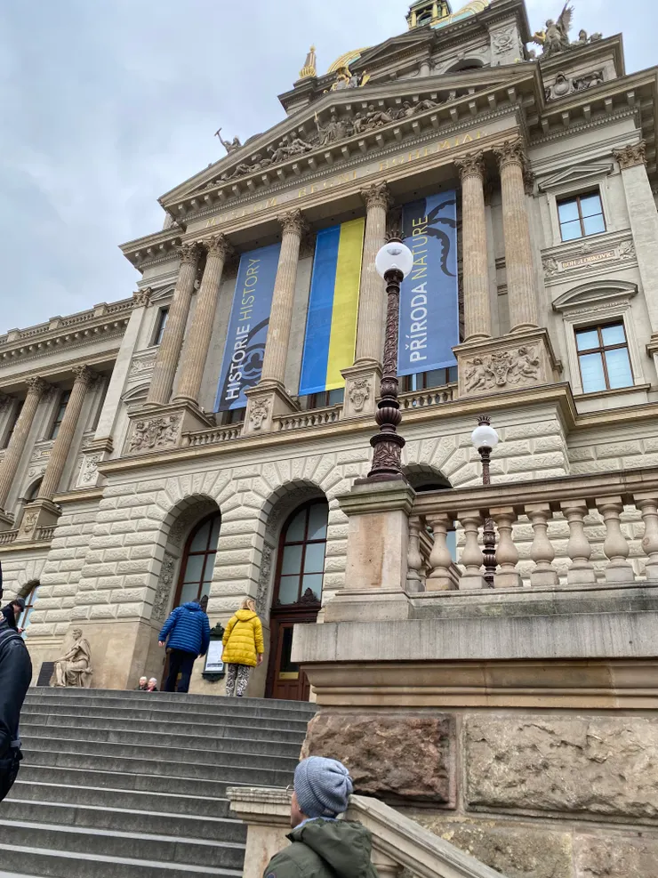 ▲捷克國家博物館張掛著藍黃色的雙色旗，為烏克蘭聲援。恰巧底下兩個小孩，分別身穿一藍一黃，與上頭的烏克蘭國旗顏色一樣。