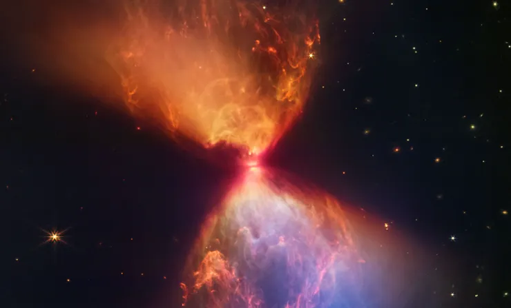 一顆明星誕生了。隱藏在這個熾熱沙漏的中心的是一團熾熱的氣體，它正在形成一顆恆星。它被稱為 L1527，只有大約 10 萬年的歷史，需要一段時間才能合併到引發核融合並成為一顆成熟的恆星。在這裡， 氣體和塵埃聚集在一起，形成一個吸積盤，在圖像中心顯示為一條小黑帶。嵌入其中的原恆星照亮了從兩側向外吹出的氣體和塵埃雲，形成沙漏形狀。藍色代表灰塵最薄的區域，橘色代表灰塵最厚的區域。  圖片來源：NASA、ESA、CSA、STScI