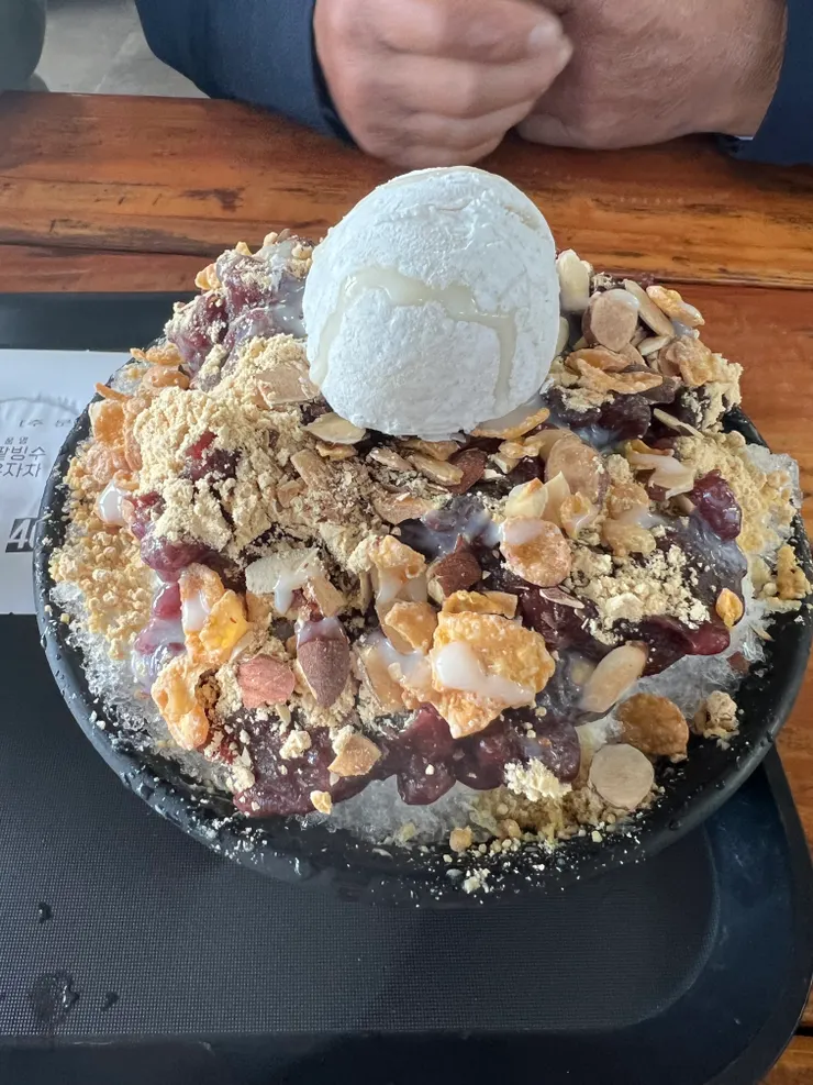 紅豆冰，最上方是紅豆麻糬，中間有幫忙切開，很貼心。紅豆泥非常綿密，不會太甜，搭配杏仁果切片和黃豆粉，非常好吃。底部的冰還是牛奶冰，不是清冰，很棒！