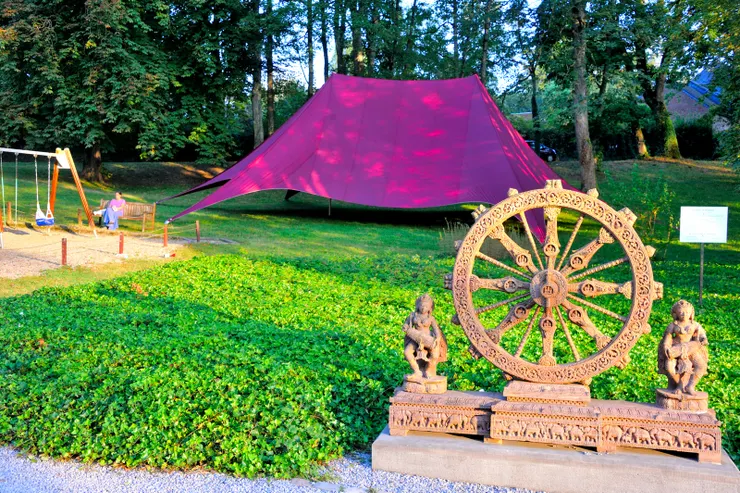 【為了四點半的敬拜老妻起個大早，唱誦聲隱隱傳出我揹著相機亂跑！接待中心前的大草地，有奉獻者在唸誦。】