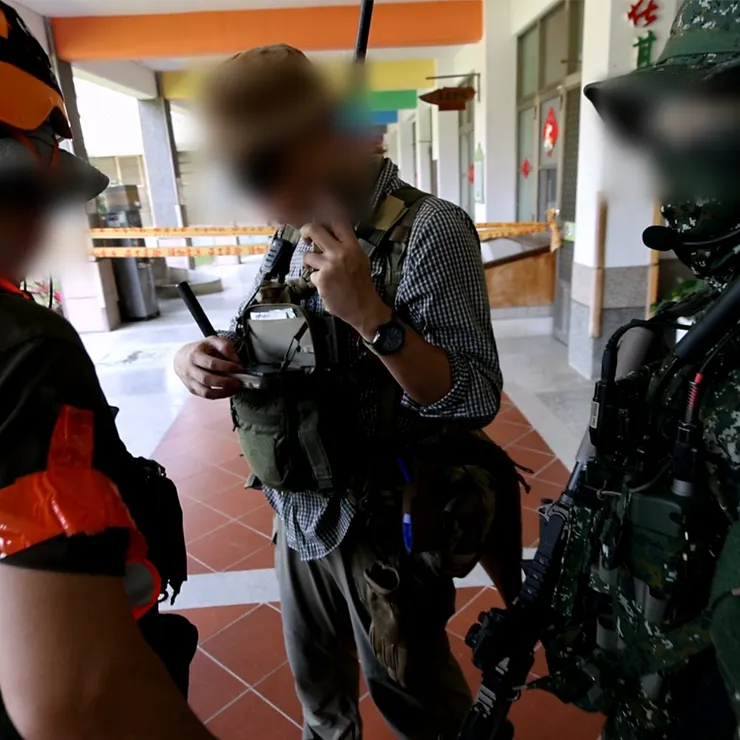 聯絡官正在同時接收來自前進組收到的情資、並將相關資訊匯報給來協助任務的國軍單位