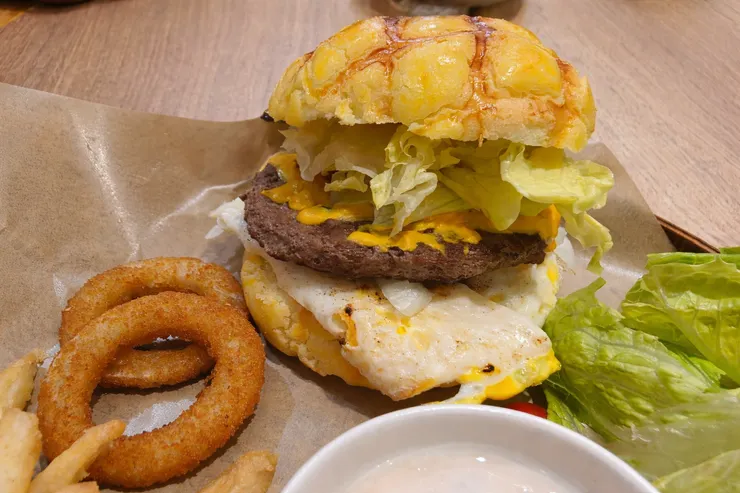 必推菠蘿堡寶!。上層甜酥菠蘿麵包，內夾厚實牛肉排＋起司＋半熟蛋＋生菜＋番茄，甜鹹交錯豐富味蕾。