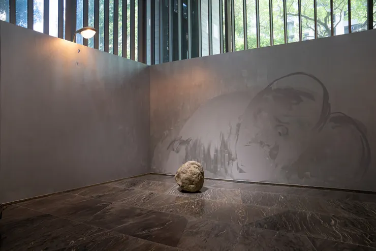 作品〈猩猩石〉（前），作品〈猩猩壁畫〉（後方牆面）