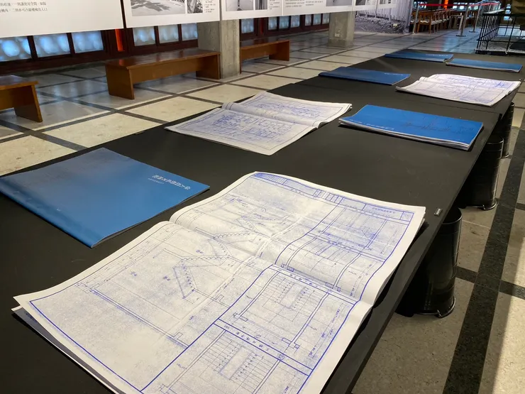 展覽中央長桌上擺放了幾棟建築的施工圖，展示主要圖面部分