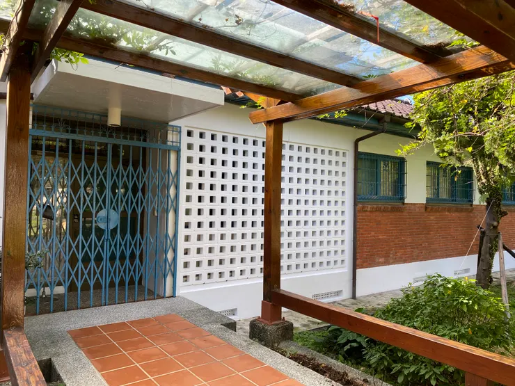 胡適故居的正門。立面為清水紅磚牆搭配水泥格子磚,抬高的屋身,入口處有幾個階梯。而現在看到的廊道是之後才墊高的。藍色鐵窗也是後來才加裝