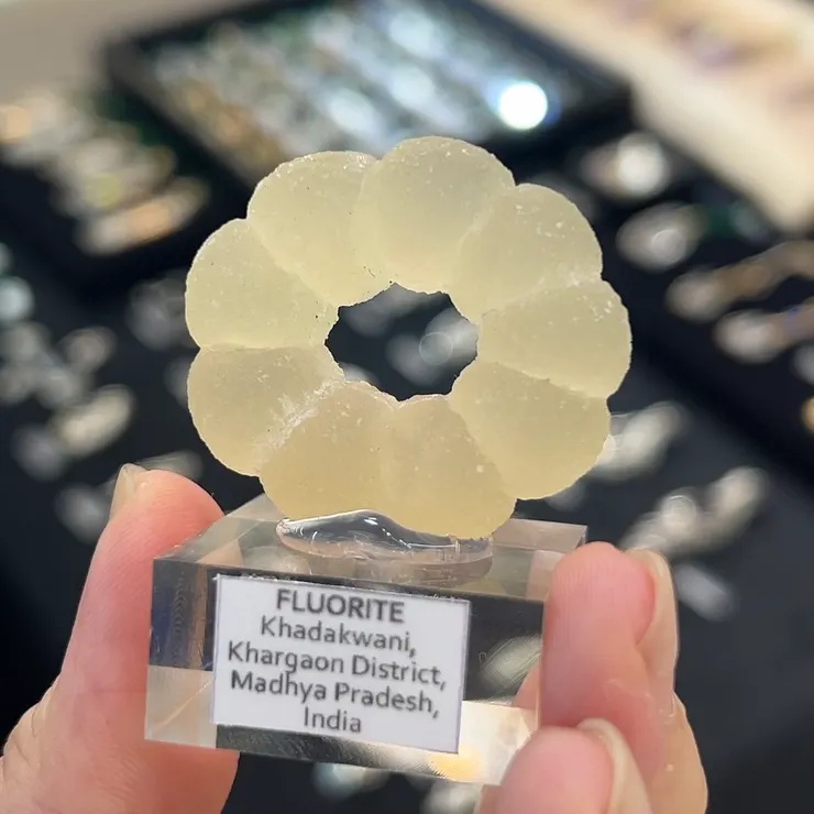 印度這種長得像甜甜圈的螢石，其構成有一些爭議，有人認為它是完全以人工雕琢而成，但展商分享這顆螢石是天然的造型，僅經過酸洗處理的。