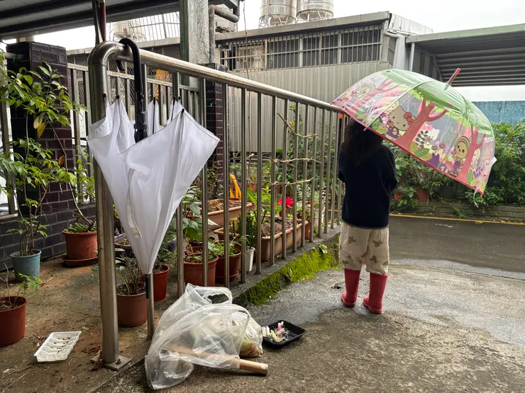 穿起雨鞋，撐起傘來，準備工作。