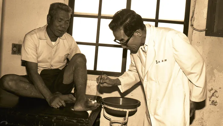 圖12 王金河為烏腳病患者患部塗藥 案名：民國68年臺灣省政府第10任省主席林洋港省政活動紀實 檔號：0068/140101/305 來源機關：國家發展委員會檔案管理局 管有機關：國家發展委員會檔案管理局