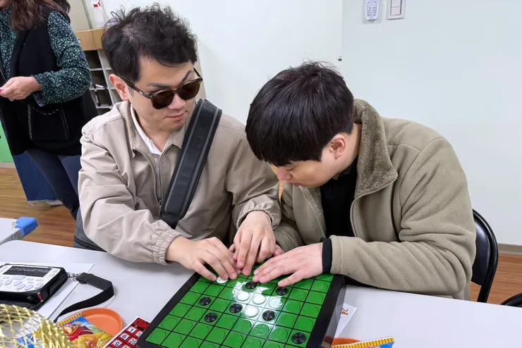 （圖說：韓國身障教師工會的貴賓藉由觸覺感受「盲用圍棋」的特殊設計。）