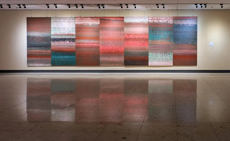 積吶虹光,〈青天白日滿地「虹」〉,壓克力顏料、宣紙,840 X 244 cm。 作品帶有隱約的紋理與筆觸,讓人聯想到自然現象,如日出日落時的天際,或是地層的積累。這些顏色之間的過渡柔和,並且彼此交疊、混融,讓人感受到一種沉靜而深邃的氛圍。