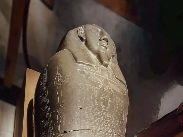 Egyptian sarcophagus carving with winged human symbolising the soul, AI used to remove bystanders.