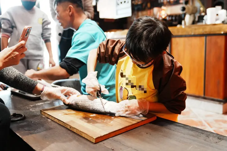  第一次殺魚的小孩～ 正在用剪刀剪開腹部， 真的是小心「懿懿」無誤～小二的懿說，這好像剖腹產！