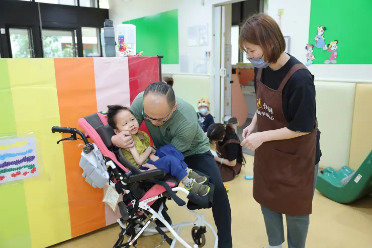 （圖說：社工協助樂樂坐上擺位椅。）
