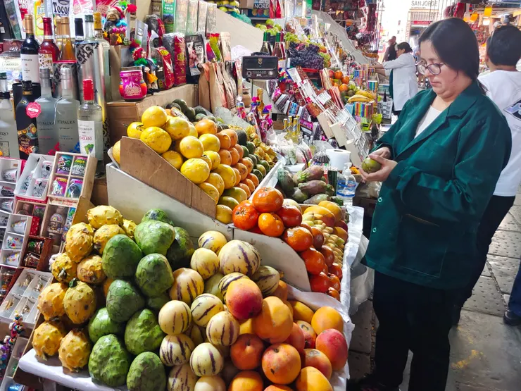 老闆娘正在切蛋黃果（Lucuma）讓我們試吃。上方黃皮的是百香果（Granadilla），下左黃或綠橢圓狀的是秘魯番荔枝（Cherimoya，鳳梨釋迦），下中有紫色條紋的是香瓜茄（Pepino Dulce，又被稱為人蔘果），下右紅或黃橙色的是芒果。