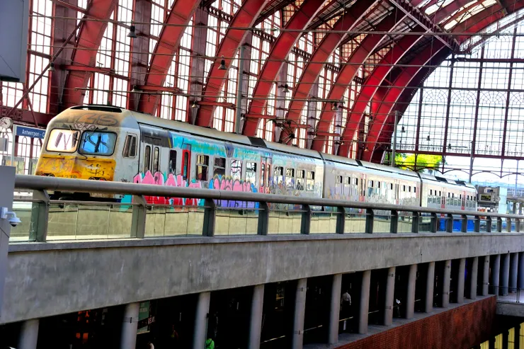 【果然嘆為觀止如皇冠鑲鑽般璨璀！安特衛普中央車站內部，4樓月台塗鴉火車進站，老實說真的和金碧輝煌的華美車站不太搭。】