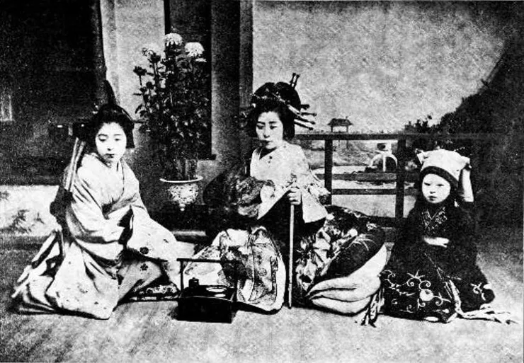 明治時代的花魁，身旁有一名遣手（左）與一名禿服務。