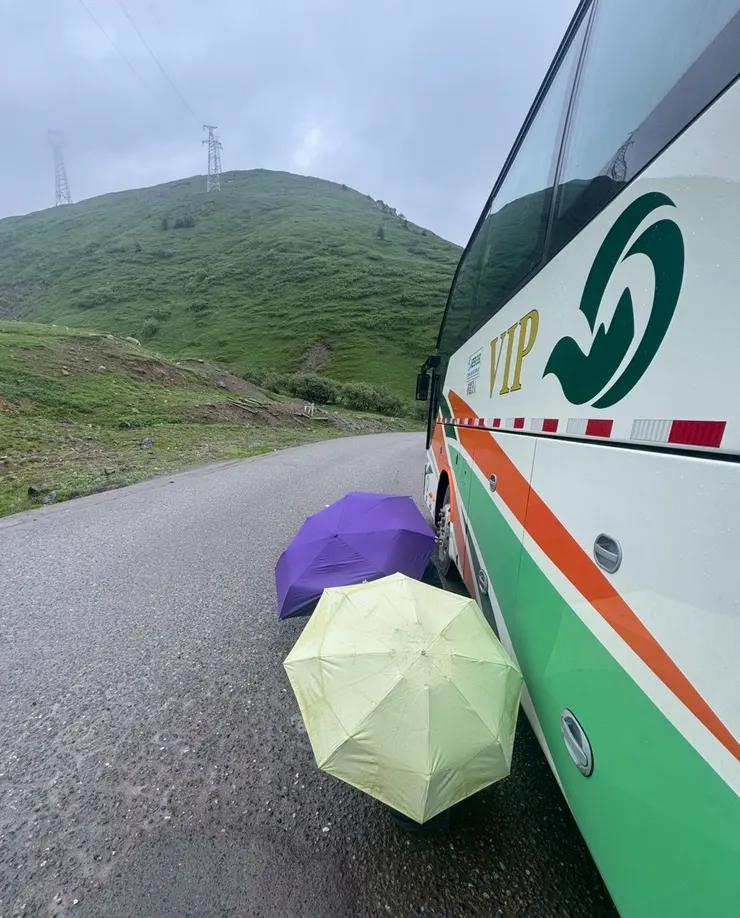 塞車太久大家憋不住尿意，下車在遊覽車旁用雨傘遮掩就地解放