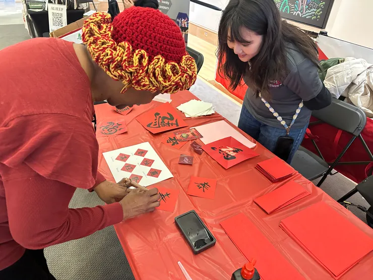 引導國外參與者體驗寫春聯書法的樂趣