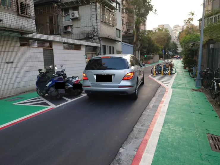 車輛通過，確實有減速效果，但是否達設計速率（20km/h）仍有待驗證。但也可以看出空間上其實給車子相當餘裕。但停放的機車就有點危險。