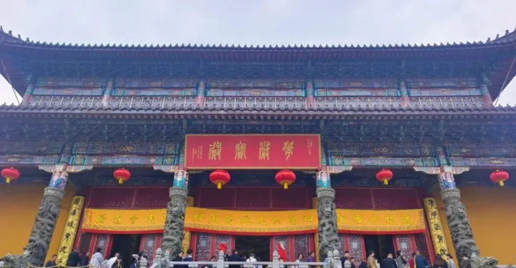 旃檀林的正面,紅色匾額上寫著「開光大吉」,黃色的大門口掛著紅燈籠,旁邊的雕像與細緻的建築細節令人印象深刻。