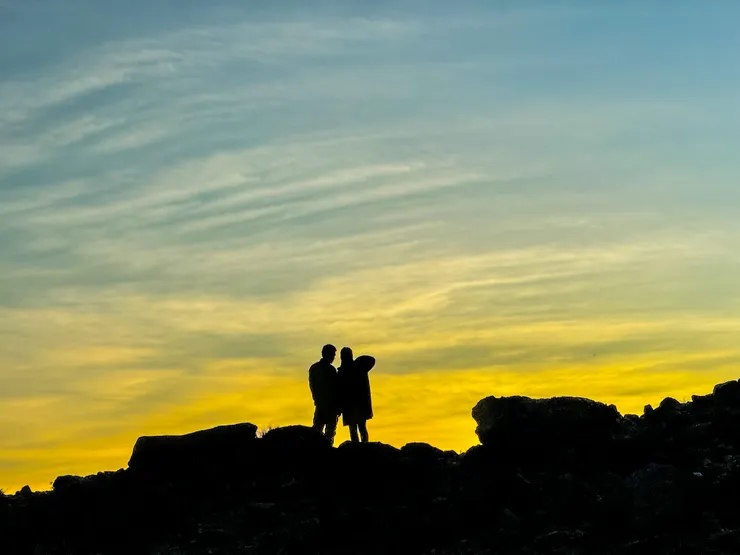 遠處的情侶正在欣賞小關山神池的夕陽