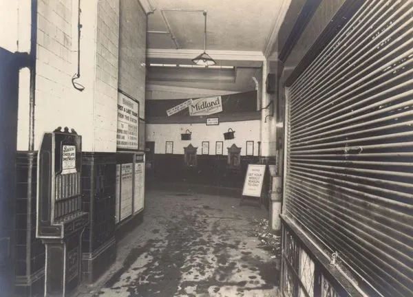 大英博物館的地鐵站過去內部的樣子，右邊有拉下鐵門的售票亭，左邊有售票機和首班及末班地鐵的時刻表，圖片來源：London Transport Museum