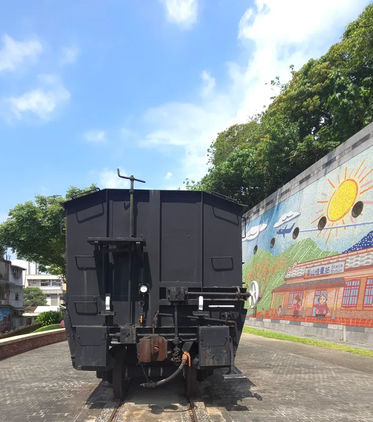 車尾對著一片彩虹壁畫。有大太陽、雲朵,還有「山佳車站」的老樣子,都在這幅畫裡。 「生活就像這幅畫,色彩斑斕、陽光燦爛」。
