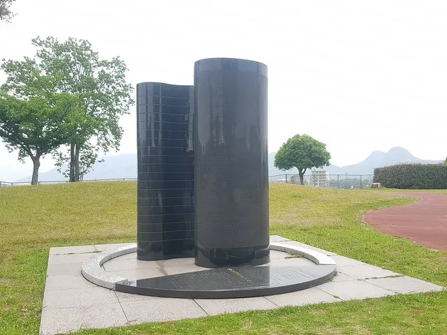 筑豐塵肺訴訟記念碑「我們不是捨石」，背景可見香春岳