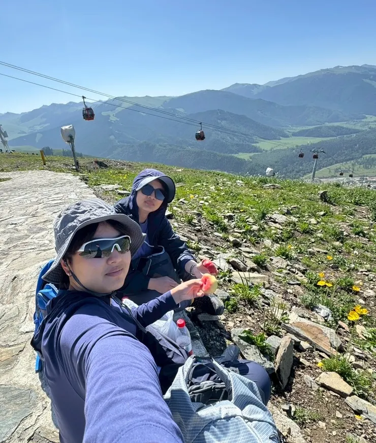 在草坡上吃水蜜桃，看著纜車緩緩升上，馬兒在一旁吃草，實在太享受了