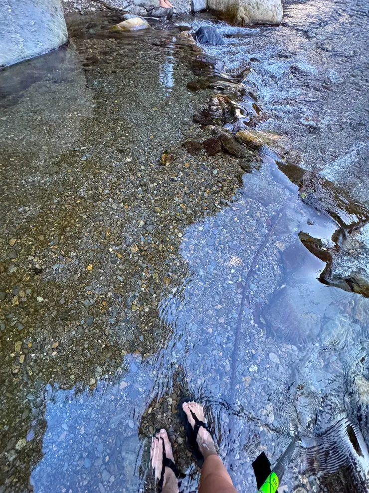 雙腳泡在冰涼的溪水裡，舒緩疲憊的腳趾