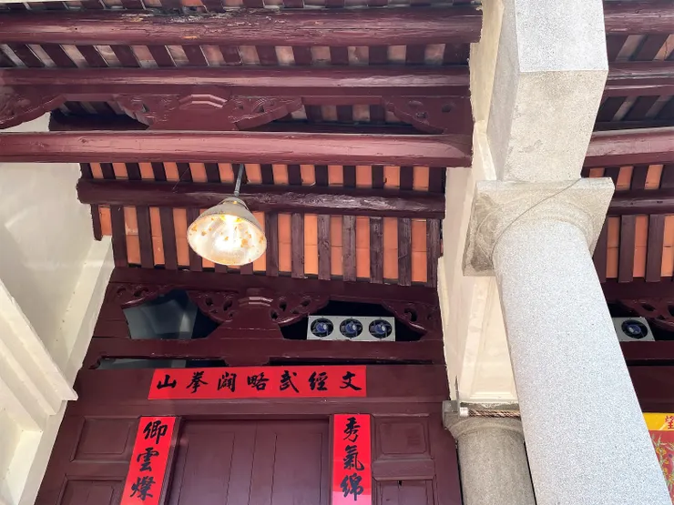 日治中期建築特色的木構屋架與洗石子柱。門上對聯出現「秀卿」字樣