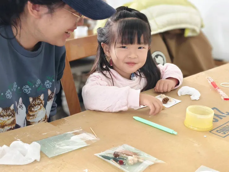 鹽水親子館課程中，孩子專注地練習手眼協調，將永生花放入擴香石。
