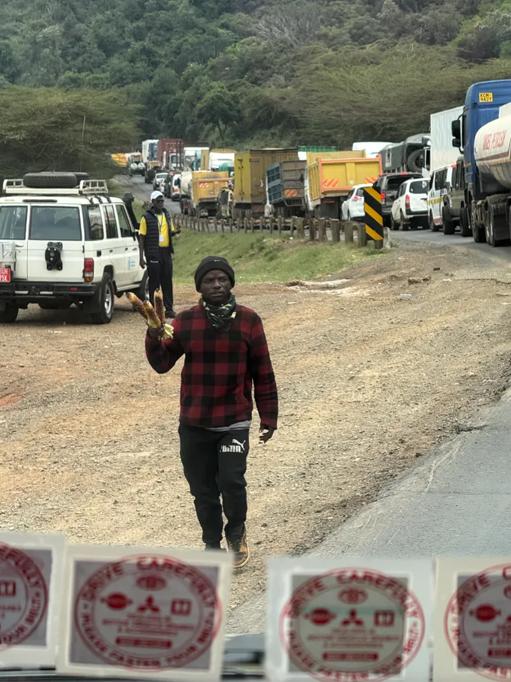 開車在公路上，沿路賣烤玉米的小販（是很原始在旁邊的草堆開始烤）一支50肯亞先令不到臺幣10元，但相當原形食物及好吃（不像臺灣會刷厚厚的烤肉醬）