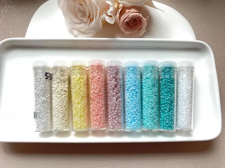 1.5mm/2mm日本玻璃小珠-顏色由左至右為透明五彩，米色，鵝黃，粉橘，淺紫，水藍，淺水藍，淺綠，白色。用來搭配天然石或珍珍做設計。