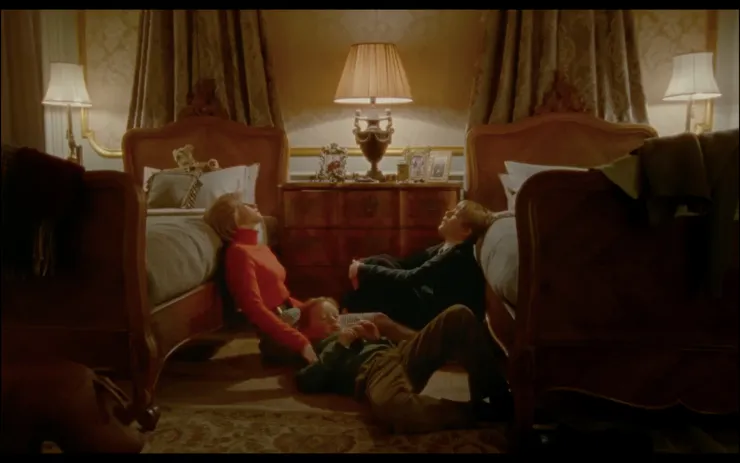 從社交活動中脫身後躲回房間的母子三人，疲憊地半躺在床沿