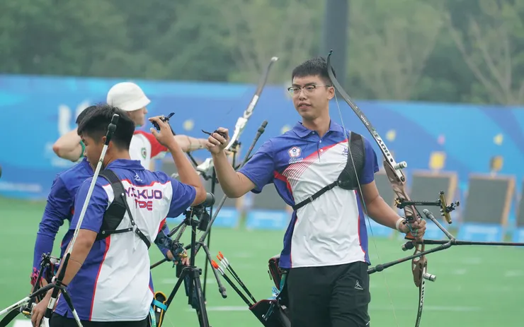 成都世大運反曲弓男團4強賽擊退義大利晉級金牌戰，選手張譯中(右) 與隊友擊掌打氣。