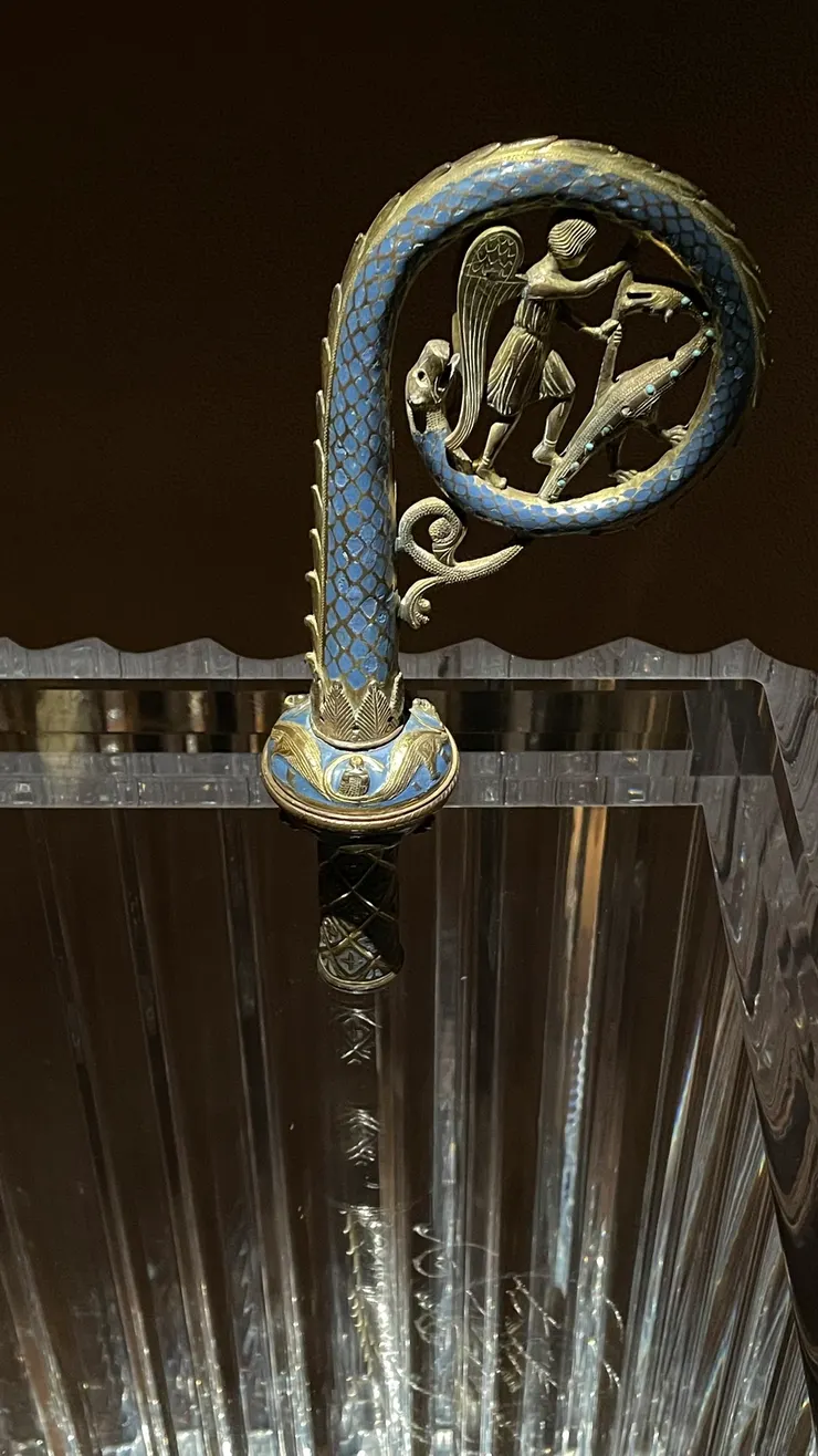 飾有聖米迦勒天使降魔記的權杖頭，十三世紀後半葉，法國，裝置藝術博物館收藏。 這次展場設計很美，雖然燈光太暗，但為了保護藝術品倒也無可厚非，唯一詬病就是解說文寫在玻璃或陰暗的角落，人潮一多、擋住光源後幾乎看不見。 因為展場設計在每個展品下方放置了鏡子，加上特別設計的打光，每個展品都有種魔幻之美。我現場看到這個權杖時，它雖只有權杖頭，但因為鏡子映射的關係，往下望，彷彿自己長出了劍身，往下插入地底，我當時還想，不會這跟我的功課有什麼關係吧，結果今早聽Podcast芷為你讀，高靈講紅地球波（我的流日走到紅地球波符），還真的就講到了權杖。