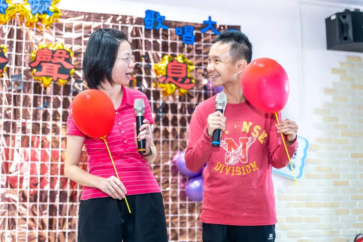 服務使用者(右)與工作人員一起合唱。