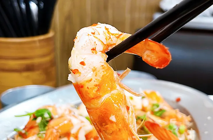 檸檬蝦微距圖，呈現Ｑ彈透亮的蝦肉紋理與香菜點綴，展現高品質食材。