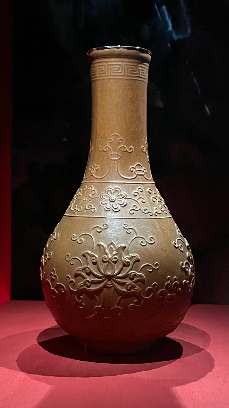 這是清康熙的葫蘆番蓮紋瓶，乍看不起眼，但原來這上面的紋飾不是雕刻上去的，而是把葫蘆幼果放到雕有花紋的模具裡，讓它長成這個模樣。