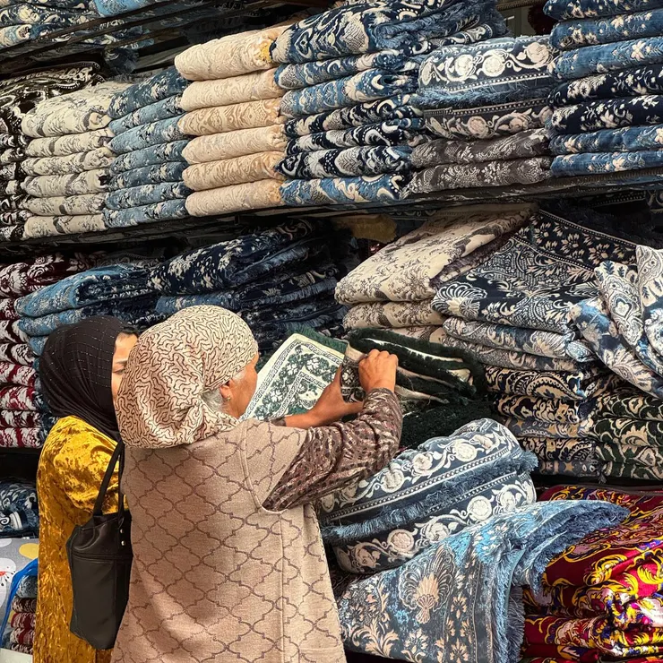 挑選毯子的烏茲別克婦女