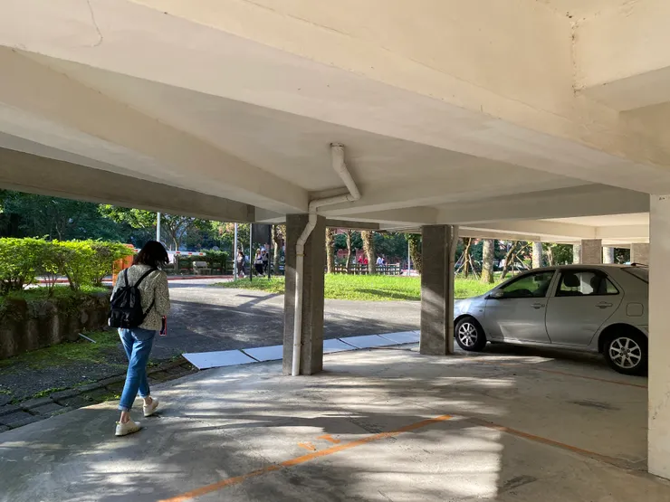 挑空的停車空間高度比一般成人身高略高，人可在底下穿梭行走，形成通透的空間感