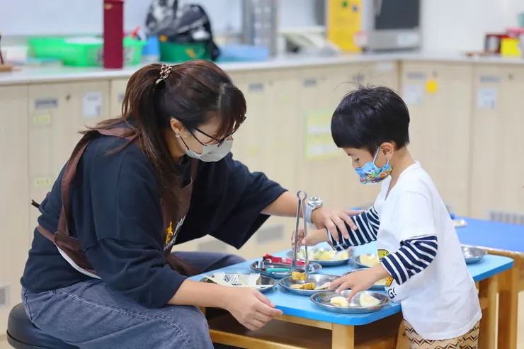 （圖說：課程中，秦瑩引導孩子使用夾子夾取水果，透過遊戲練習手部精細動作，同時認識各式水果。）